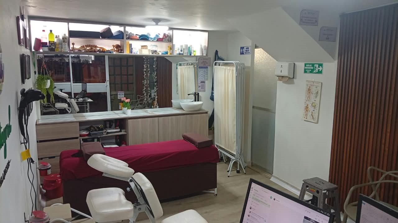 Sala de terapias de Alivio Integral con camilla, silla de masaje y lavamanos
